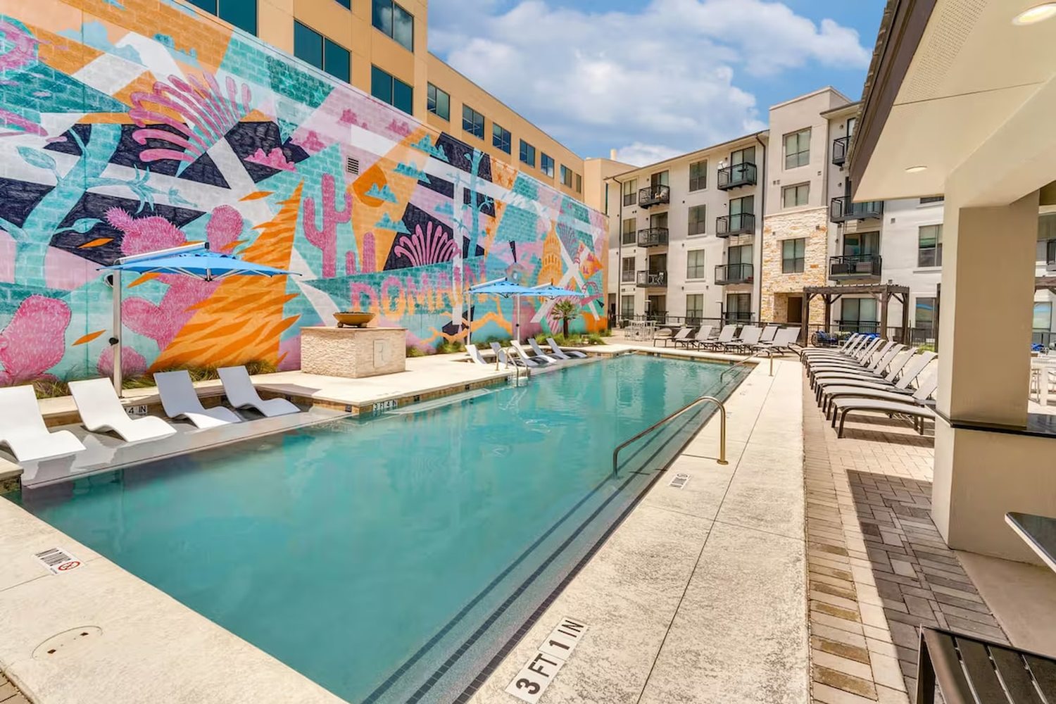 Resort-style pool framed by a colourful mural