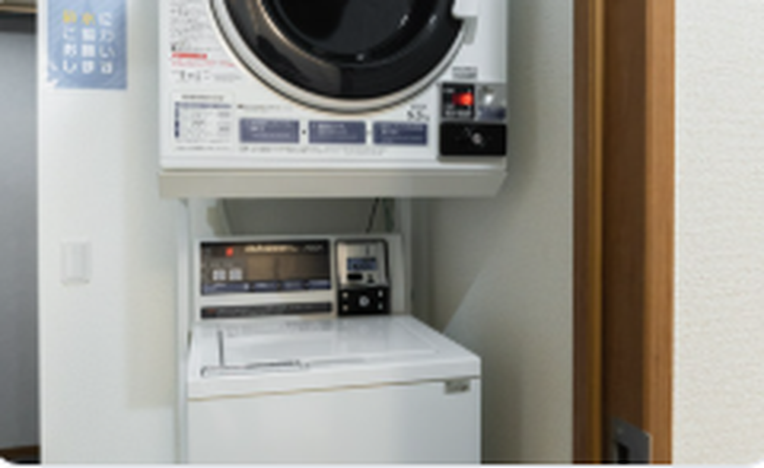 Stacked washing machine and clothes dryer in a laundry alcove.