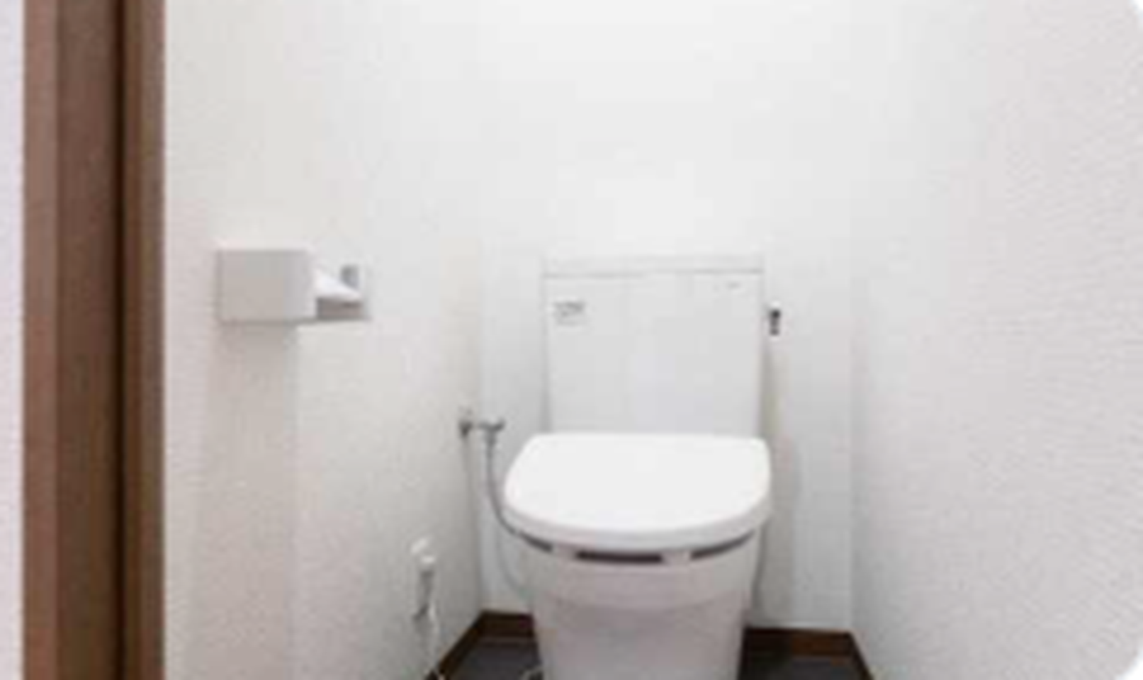 A minimalist restroom with a white toilet and white textured walls.